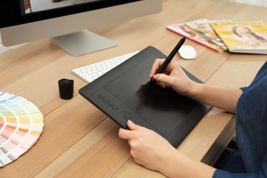 Photo of Professional designer working on graphic tablet at desk, closeup