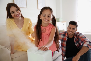 Family near modern air humidifier at home