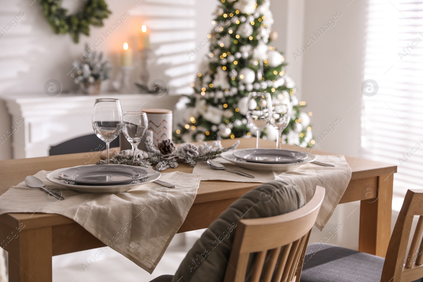 Photo of Festive table setting and beautiful Christmas decor in living room. Interior design