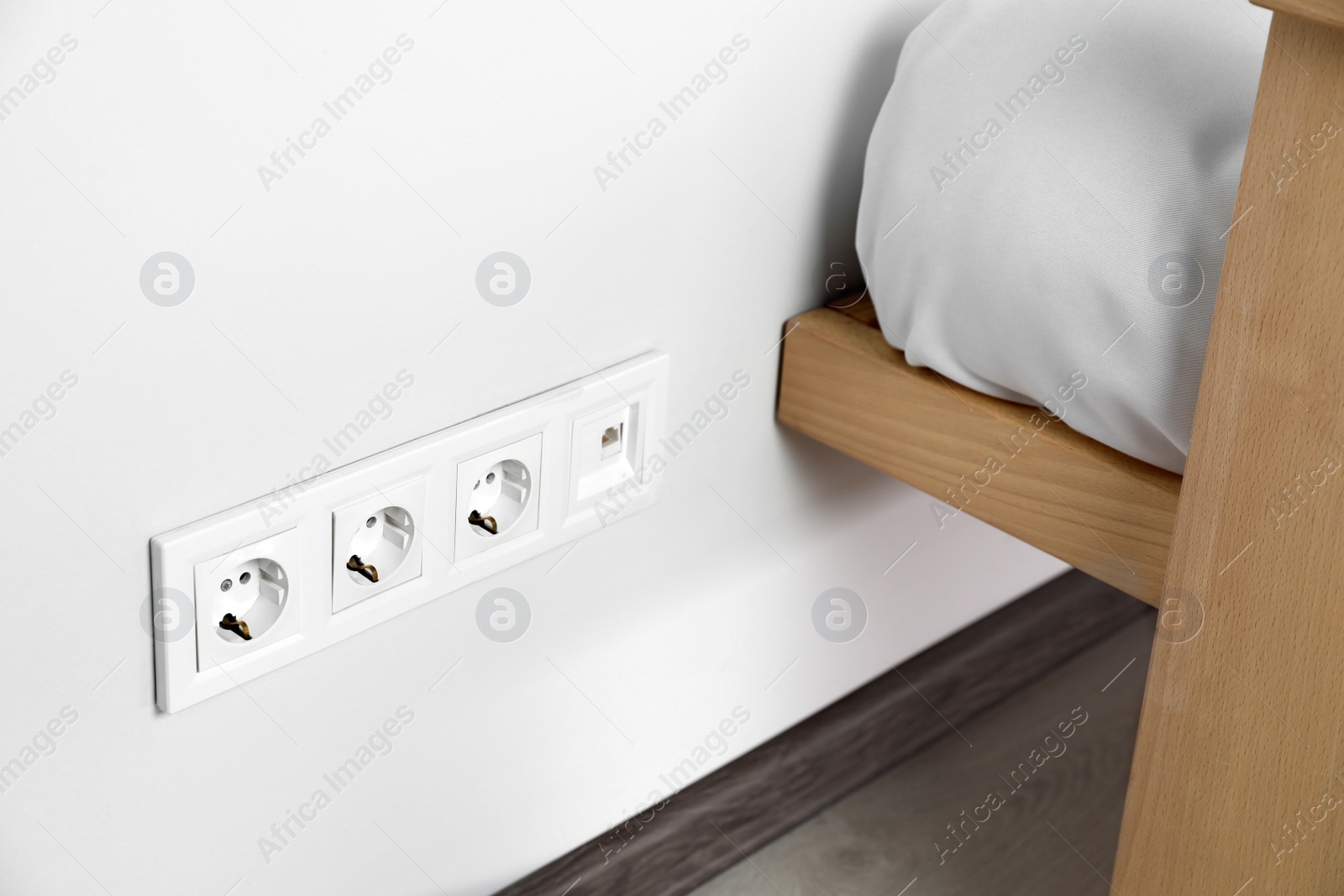 Photo of Power sockets on white wall indoors. Electrical supply