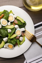 Photo of Delicious salad with boiled eggs, feta cheese and salmon served on wooden table, flat lay