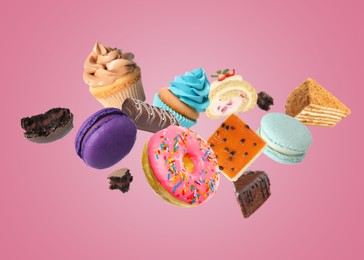 Image of Many different tasty desserts flying on pink background