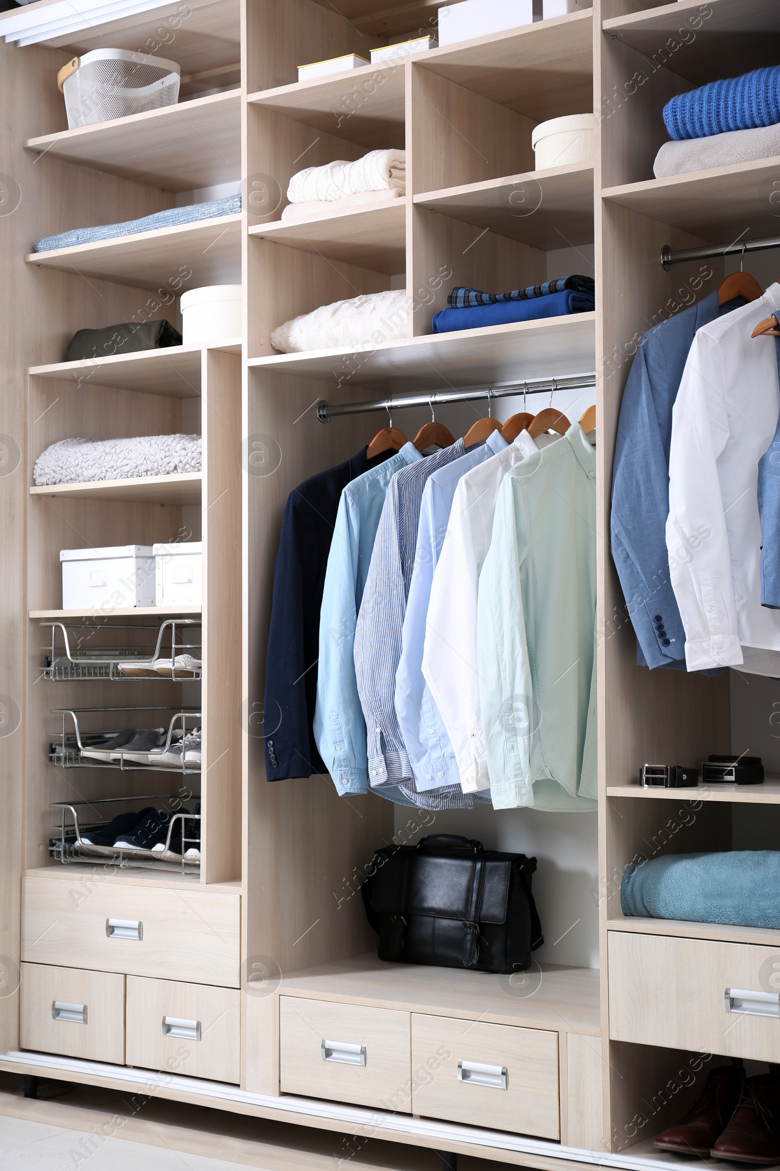 Photo of Stylish clothes, shoes and home stuff in large wardrobe closet