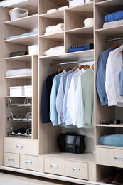 Photo of Stylish clothes, shoes and home stuff in large wardrobe closet