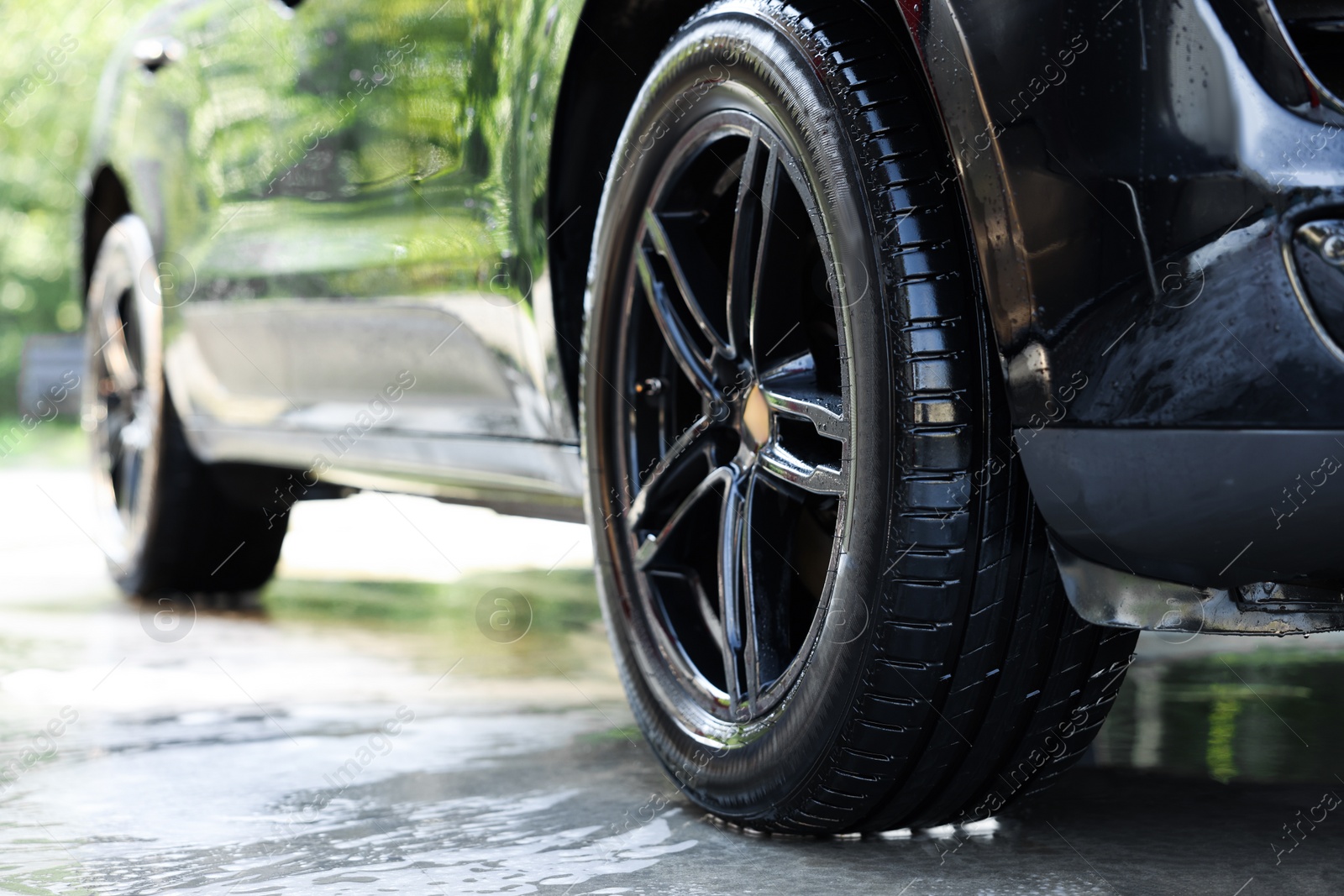 Photo of Clean auto after washing at outdoor car wash, closeup