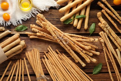 Photo of Flat lay composition with delicious grissini sticks on wooden table