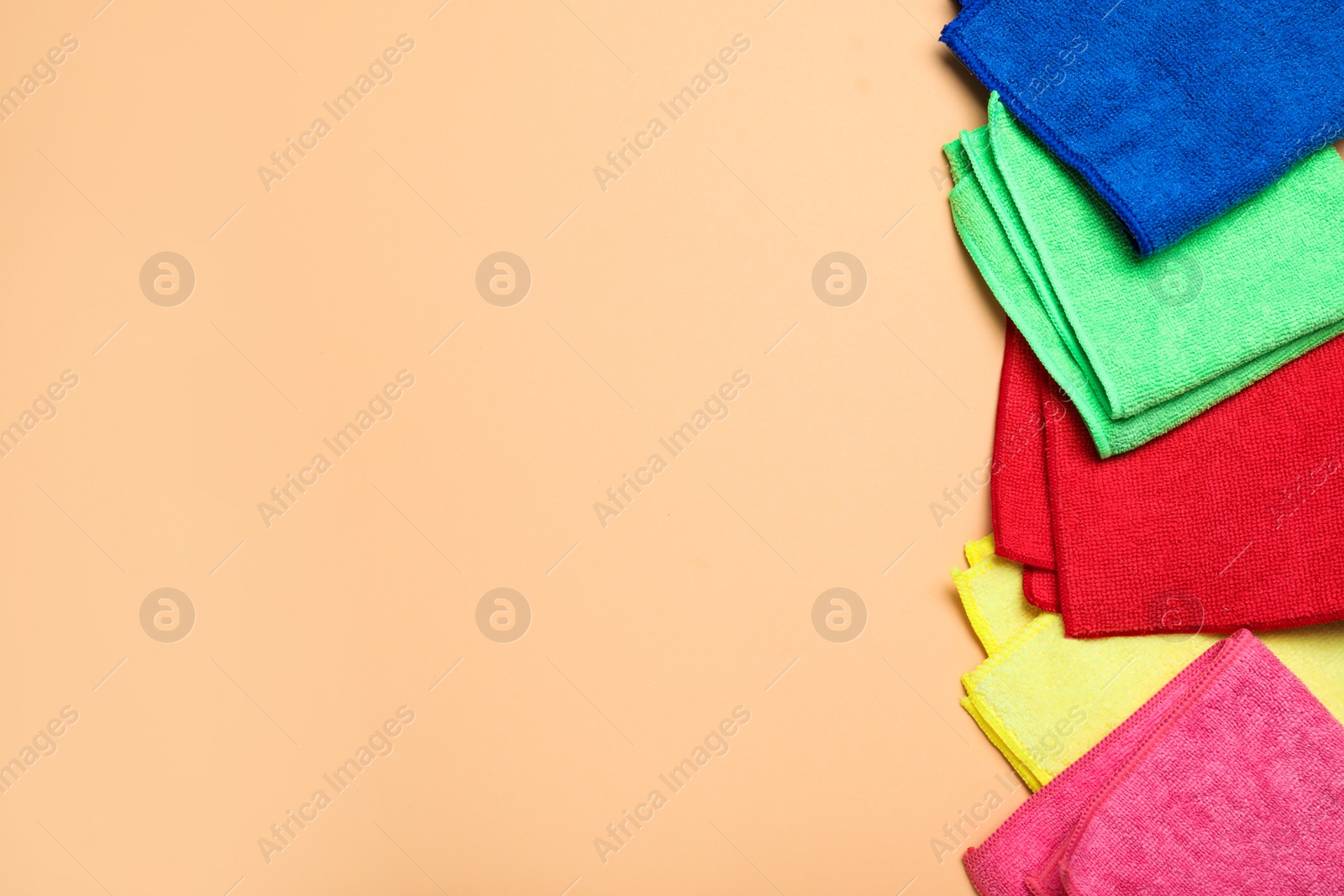 Photo of Many colorful microfiber cloths on beige background, flat lay. Space for text