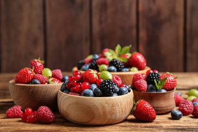 Photo of Mix of ripe berries on wooden table