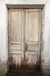 Old weathered front wooden door with peeling paint