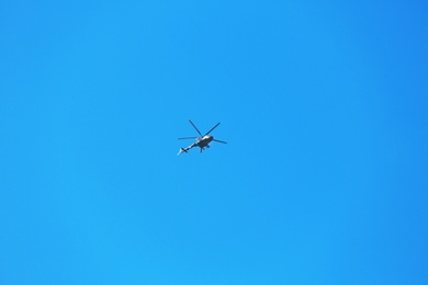 Photo of Modern military helicopter flying in blue sky