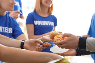 Volunteers serving food to poor people, closeup