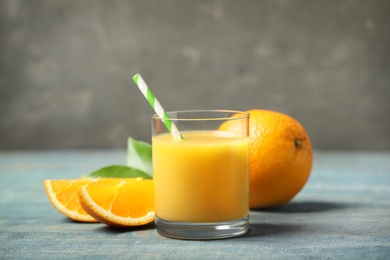 Glass of orange juice and fresh fruits on wooden table