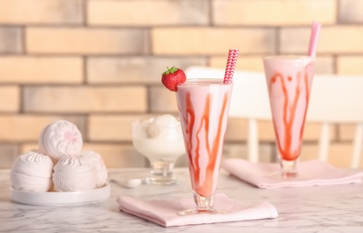 Photo of Glasses with delicious milk shakes on table