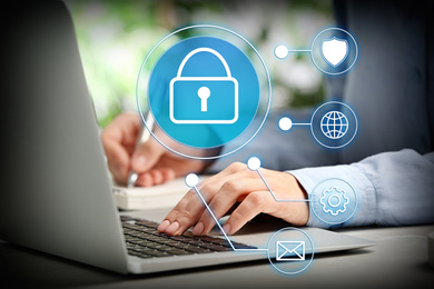 Image of Information security. Young woman using laptop at table indoors, closeup