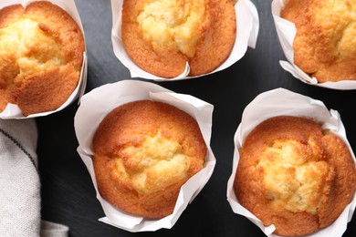 Photo of Delicious sweet muffins on black slate plate, flat lay