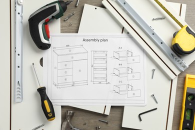 Flat lay composition with furniture parts and tools for self-assembly on wooden background