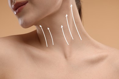 Image of Woman with perfect skin after cosmetic treatment on beige background, closeup. Lifting arrows on her neck
