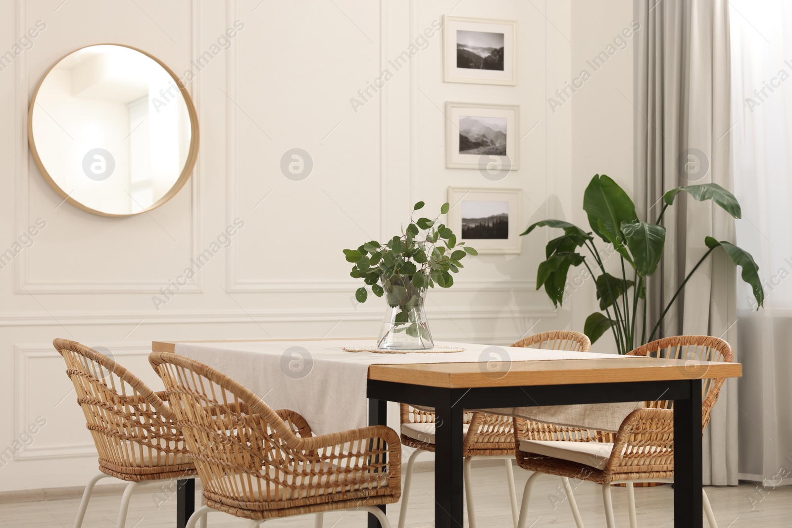 Photo of Stylish dining room with cozy furniture, mirror and plants