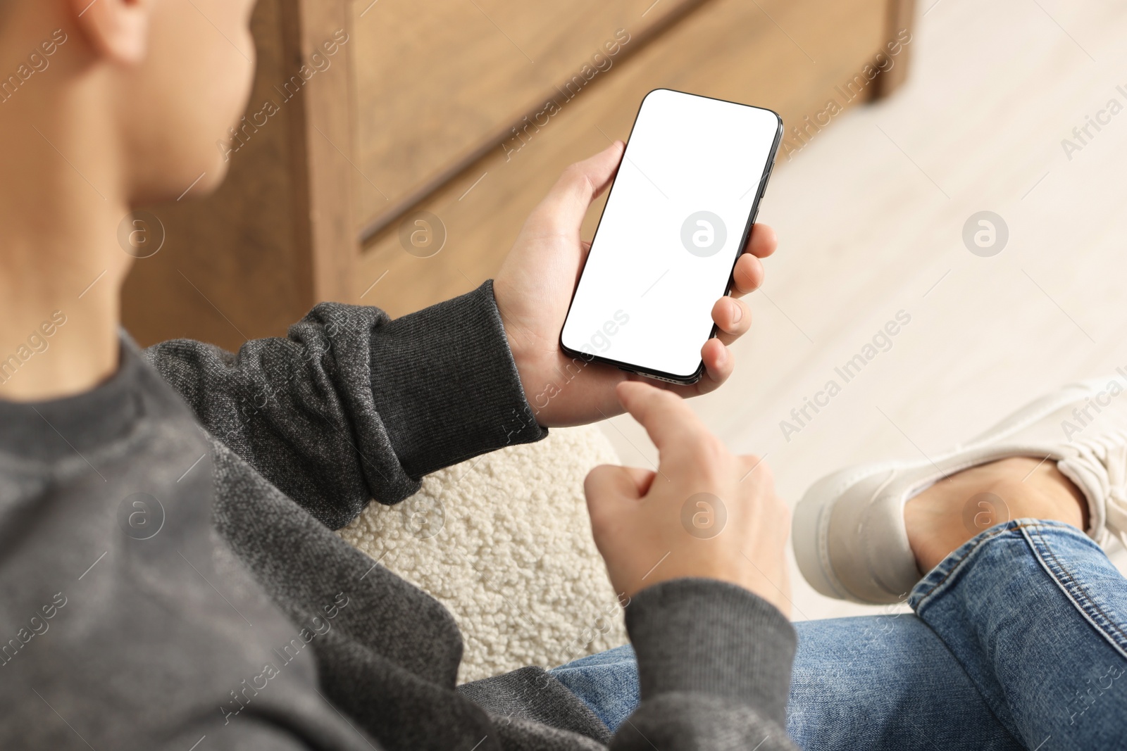 Photo of Man using smartphone with blank screen indoors, closeup. Mockup for design