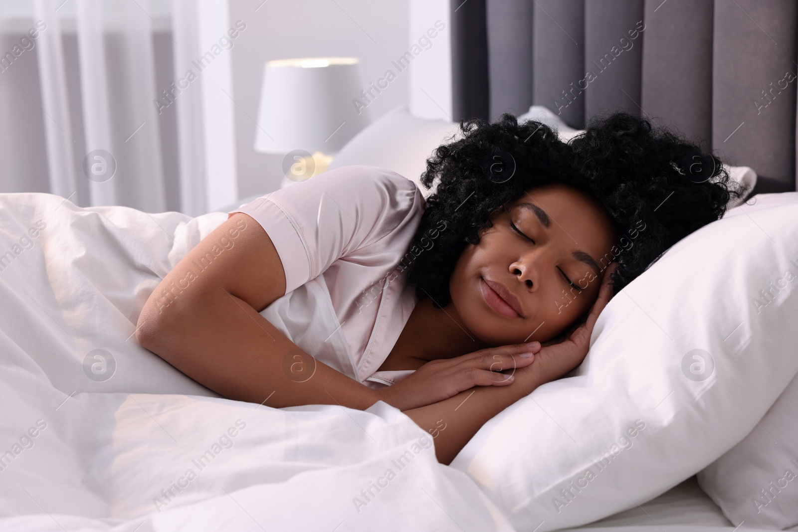 Photo of Beautiful young woman sleeping in soft bed at home