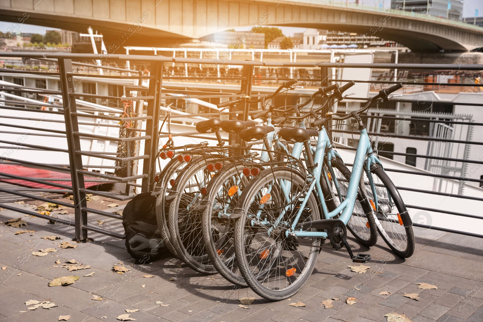 Photo of Many parked bikes near modern bridge outdoors