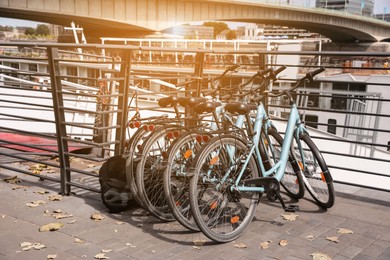 Photo of Many parked bikes near modern bridge outdoors