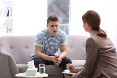 Photo of Psychotherapist working with young man in office