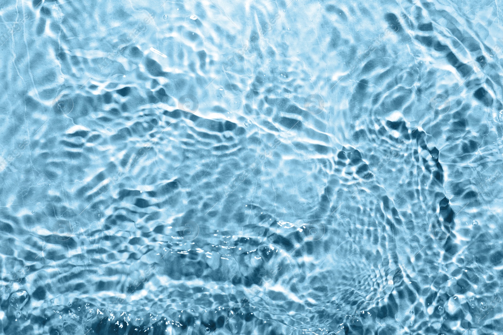 Image of Rippled surface of clear water on light blue background, top view