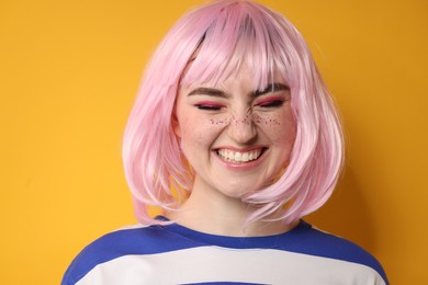 Happy woman with bright makeup and glitter freckles on yellow background