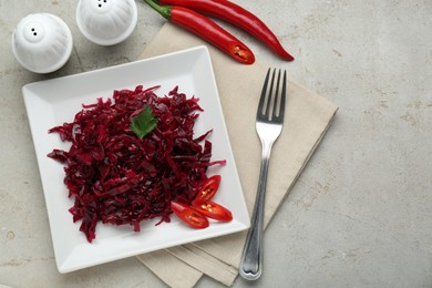 Photo of Tasty red cabbage sauerkraut with chili pepper and parsley served on light table, flat lay. Space for text