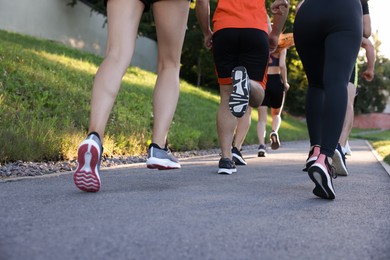 Photo of Group of people running outdoors, closeup view