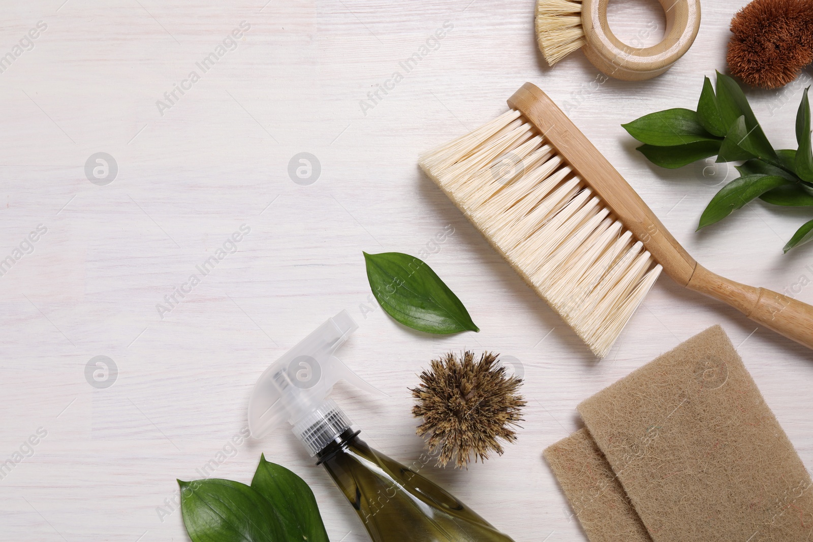 Photo of Flat lay composition with different cleaning supplies on light wooden background, space for text