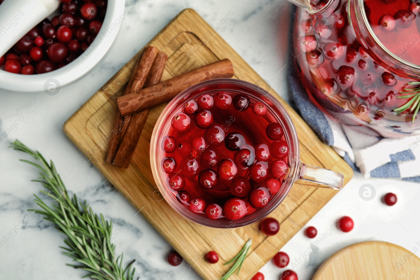 Photo of Flat lay composition with tasty hot cranberry tea and fresh ingredients on white marble table