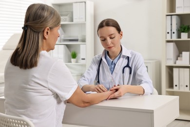 Photo of Arthritis symptoms. Doctor examining patient's wrist in hospital