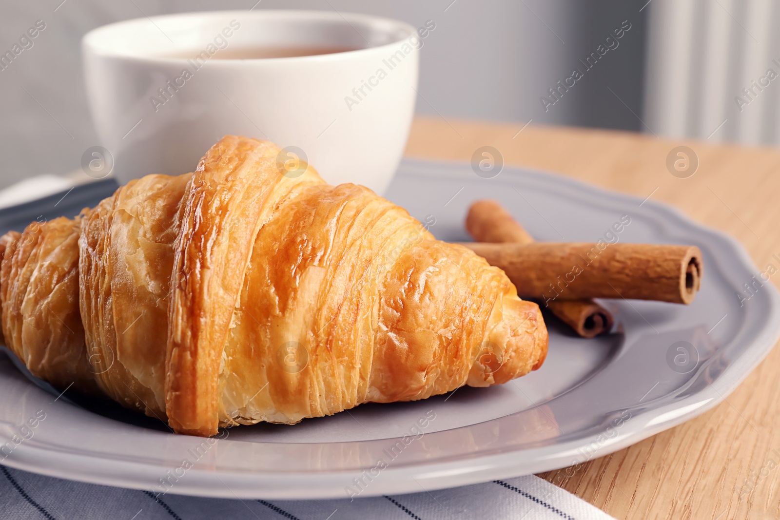 Photo of Plate with tasty croissant on table, closeup