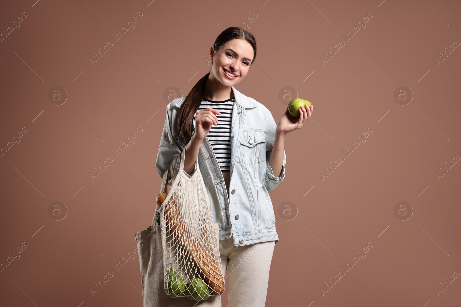 Photo of Woman with eco bags and pear on pink background