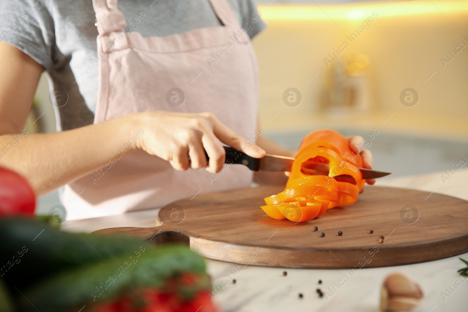 Photo of Young woman cooking at table in kitchen, closeup