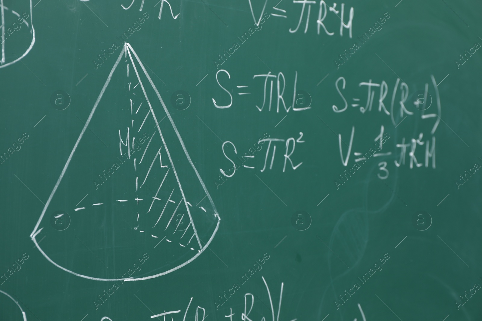 Photo of Different math formulas written with chalk on green board