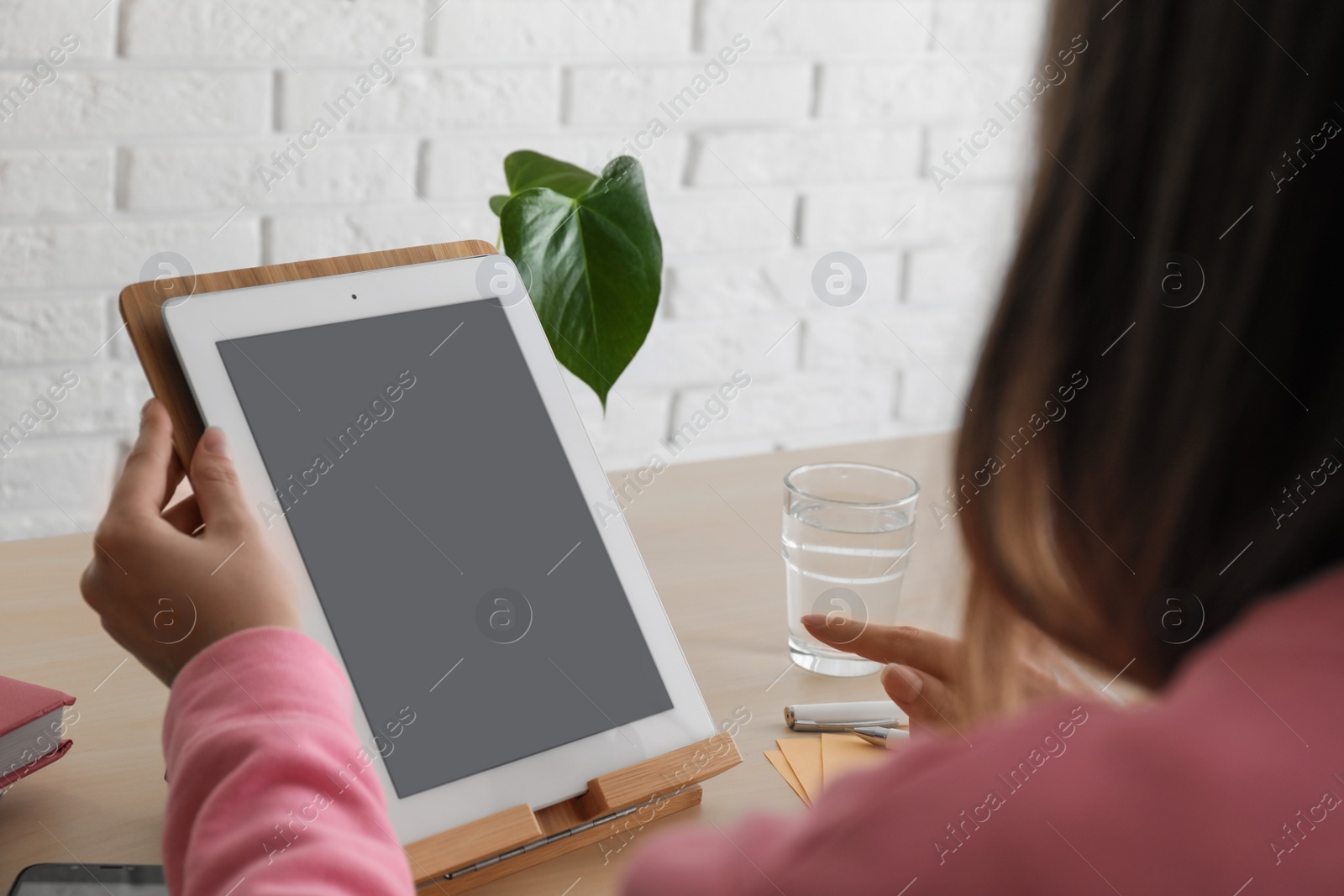 Photo of Woman video chatting on tablet at table, closeup. Space for design