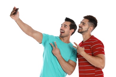 Happy young men taking selfie on white background