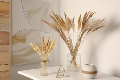 Dry plants on white table indoors. Interior design