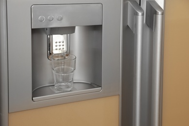 Photo of Refrigerator with ice and water system, closeup. Modern kitchen appliance