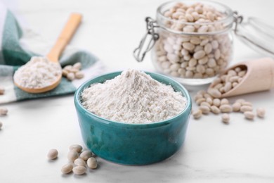 Bean flour and seeds on white marble table