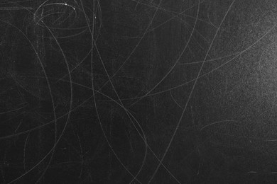 Texture of scratched black surface as background, closeup