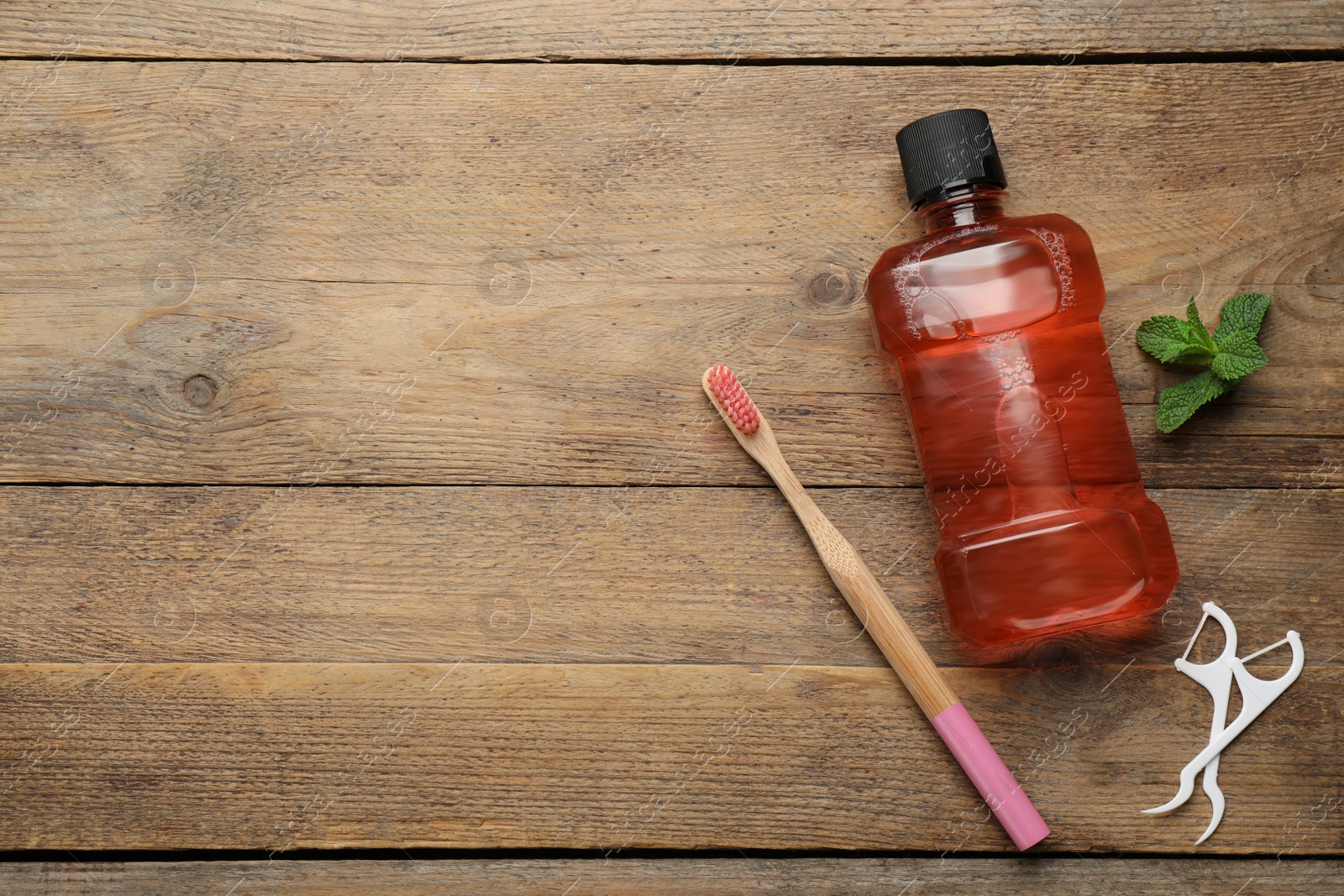 Photo of Flat lay composition with mouthwash and other oral hygiene products on wooden table. Space for text