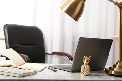 Stylish workplace with different golden accessories indoors. Idea for interior design