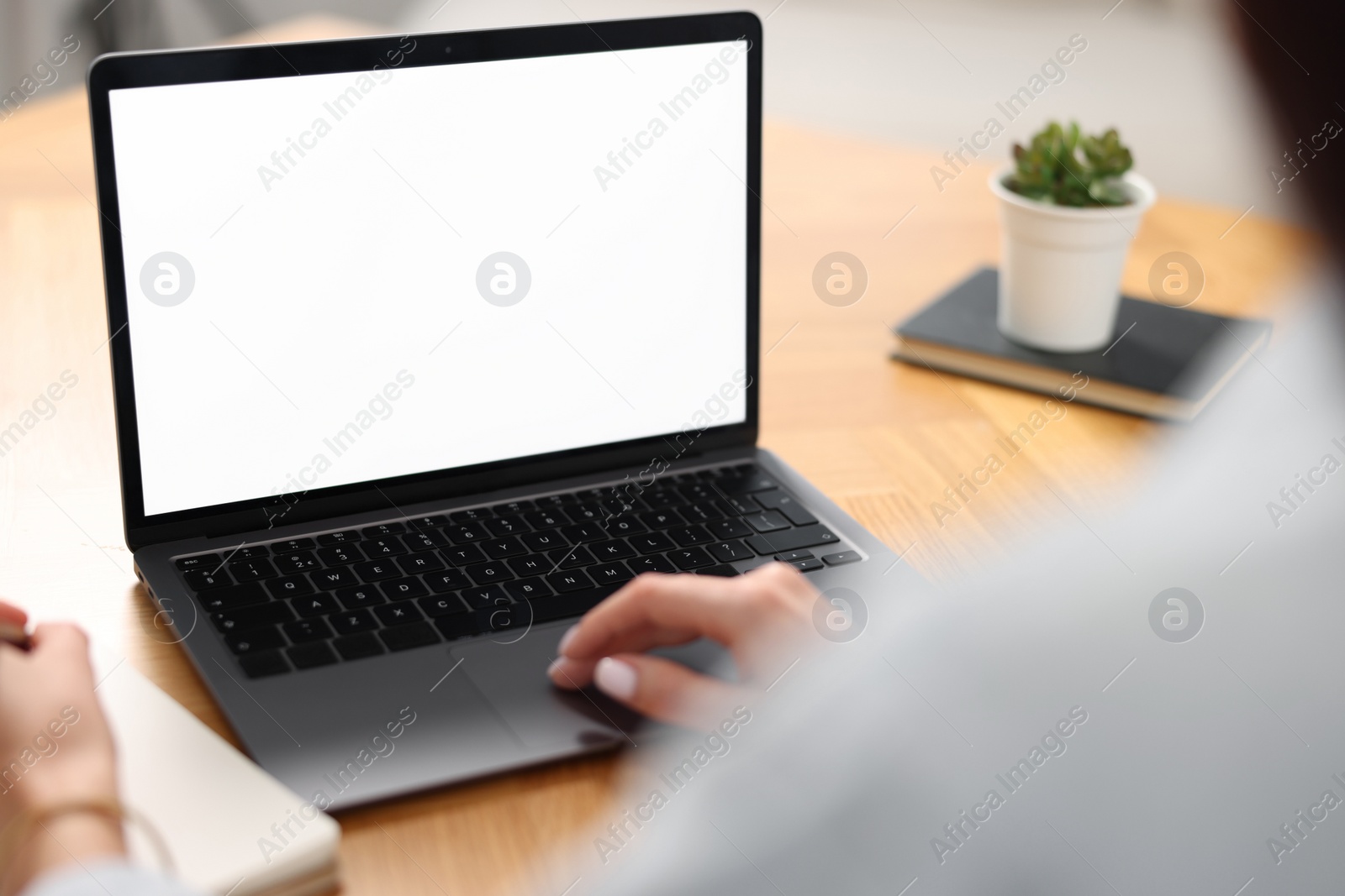 Photo of Young woman watching webinar at table indoors, closeup