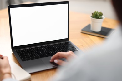 Young woman watching webinar at table indoors, closeup