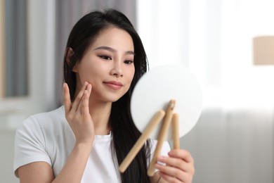 Photo of Woman with perfect skin looking at mirror indoors