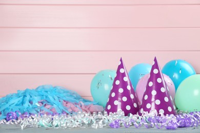 Photo of Colorful serpentine streamers and other party accessories on grey wooden table. Space for text